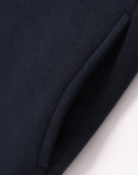 A close-up of a navy fleecy jumper featuring a half-zip collar and pockets. The fabric appears soft and textured.