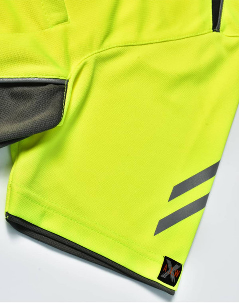 A close-up of a bright yellow polo shirt featuring grey accents and a logo on the hem.