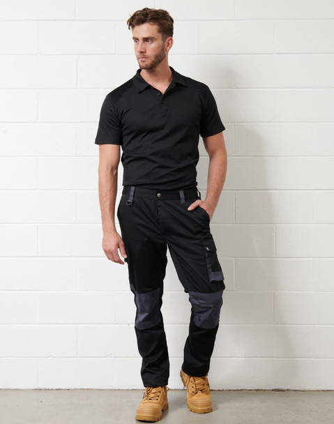A black short-sleeve polo shirt worn with dark trousers and work boots, featuring a logo on the shirt.