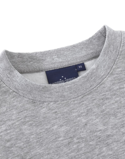 A grey crew fleece jumper with a round neckline and a tag featuring logos.