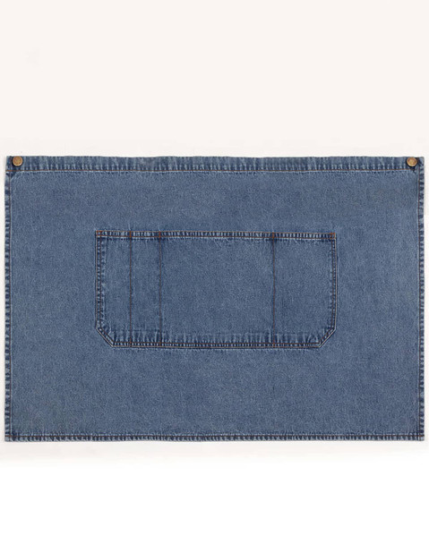 A denim half apron in blue with a front pocket and brass button accents. It has a simple, functional design.