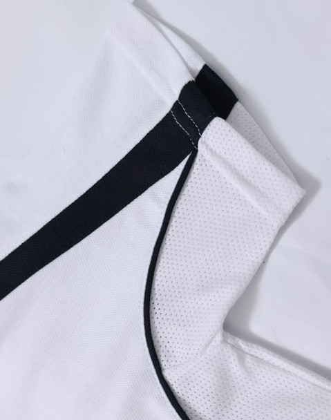 A white polo shirt with black trim and a textured fabric. It has a logo featured on it.