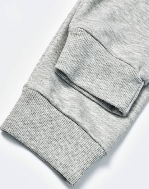 A pair of grey poly/cotton terry sweat pants with ribbed cuffs. The image highlights the fabric texture.
