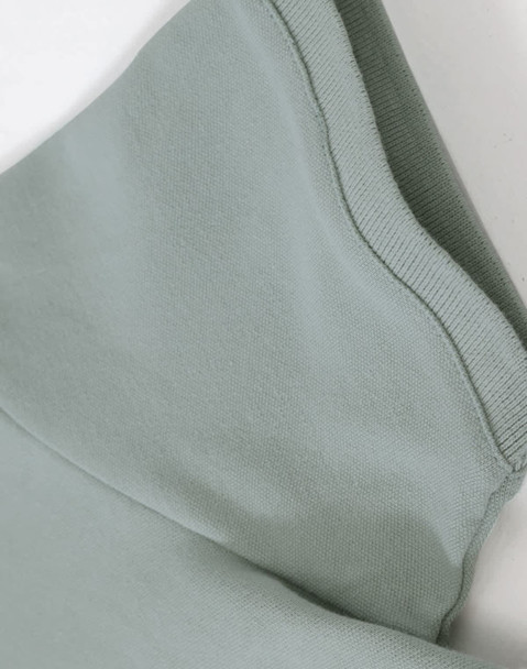 A close-up of a light green ladies cotton stretch polo, highlighting the fabric and collar details.