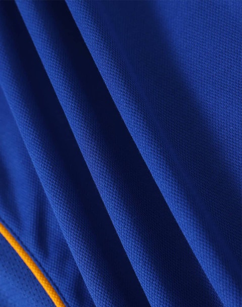 A close-up of a blue polo shirt with textured fabric and a yellow accent, featuring a logo.
