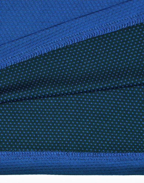 A close-up of a blue and dark green polo shirt featuring a textured fabric and a logo.