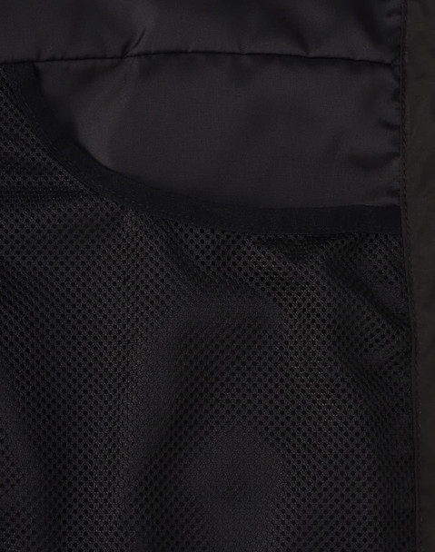 A close-up of the interior of a black insulated puffer jacket, featuring mesh pockets.