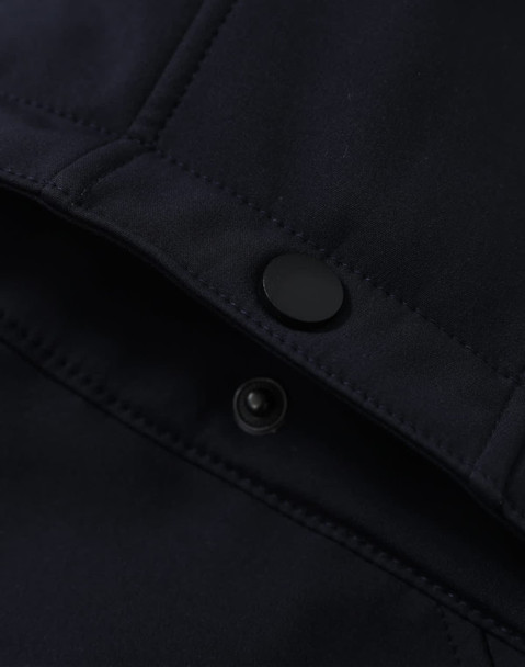 A close-up of a navy softshell jacket featuring a snap button and interior stitching details.