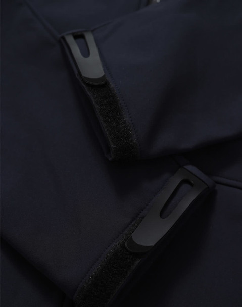 A dark navy softshell hoodie featuring zippered pockets and Velcro closures. It has a sleek and modern design.