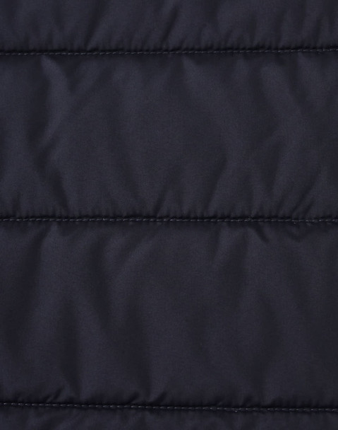 A close-up of a navy blue insulated puffer jacket fabric with a stitched, quilted pattern and a logo.