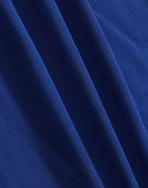 A close-up of deep blue fabric, showcasing a smooth texture with subtle woven patterns.
