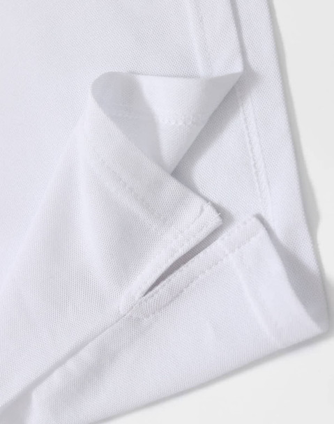A close-up of a white polo shirt featuring a folded hem and a subtle logo.