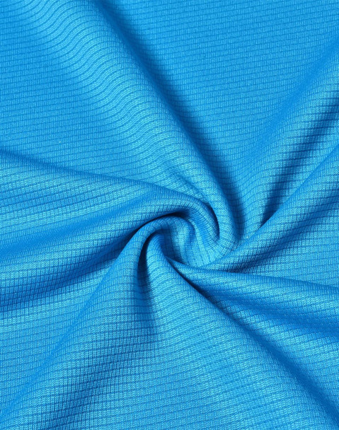 A close-up of a textured fabric in a vibrant blue colour, featuring a grid pattern. The material is lightweight and performance-oriented.