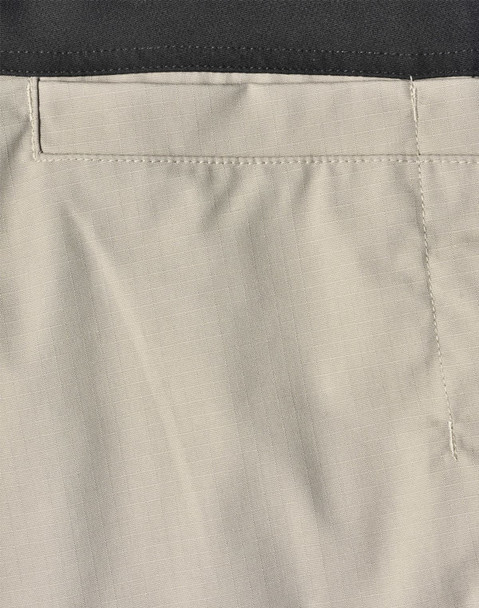 Rip-stop poly/cotton stretch work pants in a light beige colour with a black waistband and stitching details.