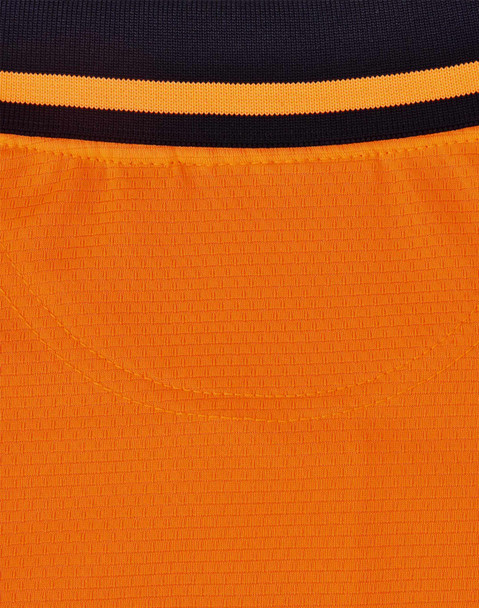 A close-up view of a unisex hi-vis polo shirt featuring orange and black colours, with a ribbed texture and a logo.