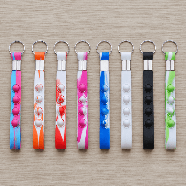 A selection of eight popper stress reliever key chains in various bright colours, featuring multiple buttons for popping.