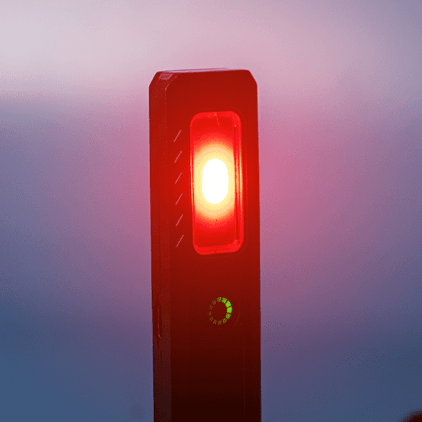 A rechargeable work light with a red light and a green indicator, featuring a sleek black design and a logo.