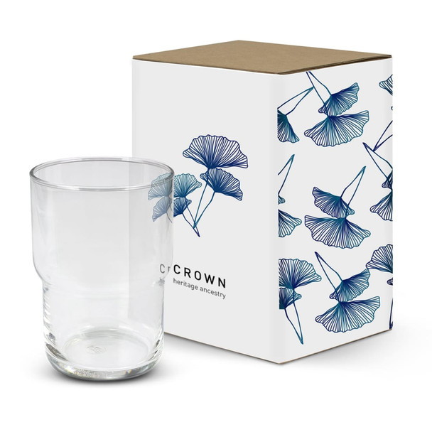 A stackable clear glass tumbler next to a decorative box featuring a floral design and a logo.