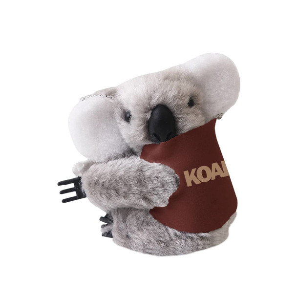A grey koala plush toy with large ears, holding a brown pouch, featuring a logo on it.