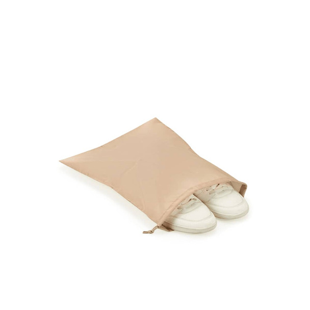 A beige shoe bag containing a pair of white sneakers, with a zipped opening at the top.