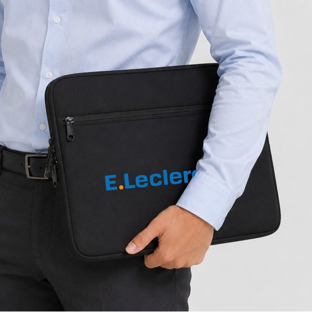 A black neoprene laptop sleeve with a logo, held by a person in a light blue shirt.