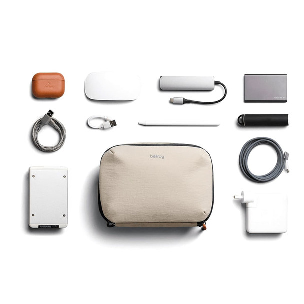 A beige tech kit containing various accessories, including a power bank, cables, and a stylus, arranged neatly.