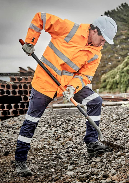 A waterproof orange jacket with reflective stripes, worn by a person digging with a spade, set in an outdoor work environment.