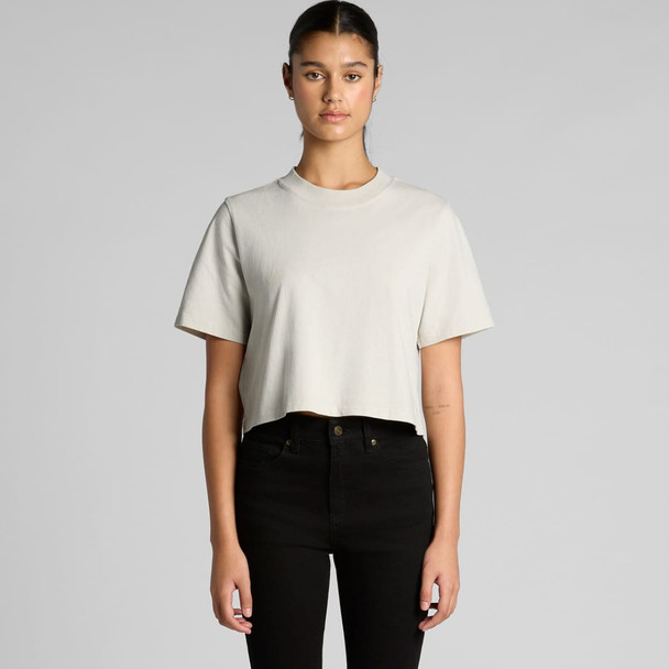 A light grey cropped t-shirt with short sleeves, worn by a model with black jeans. The shirt features a logo.