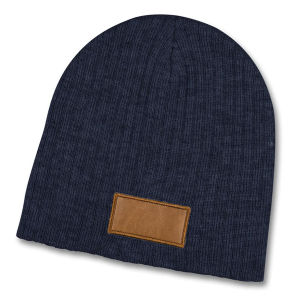 A navy blue cable knit beanie with a brown patch. The beanie has a textured pattern and is soft.