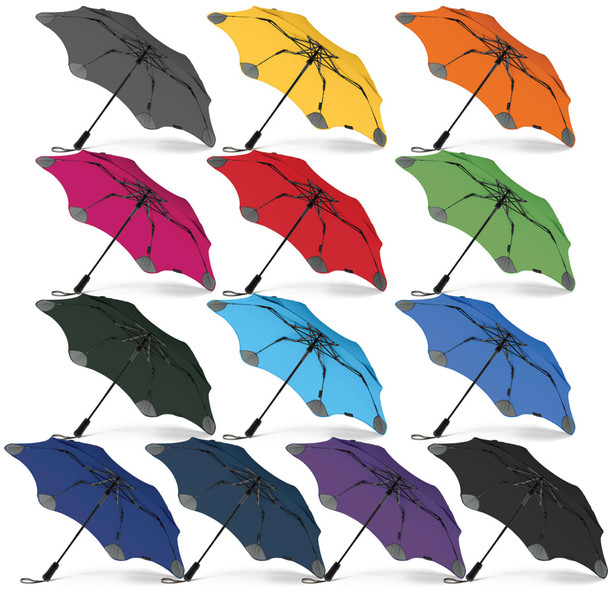 A collection of BLUNT Metro Umbrellas in various colours including grey, yellow, orange, pink, red, green, blue, black, and purple. A collection of BLUNT Metro Umbrellas in various colours including grey, yellow, orange, pink, red, green, blue, black, and purple.