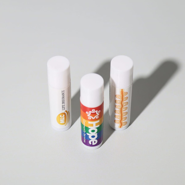 Three tubes of lip balm in white and multicoloured packaging, featuring logos.