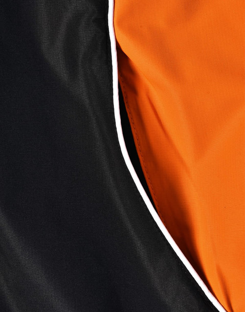 A close-up of a unisex jacket featuring a black exterior with an orange interior and contrasting white piping.