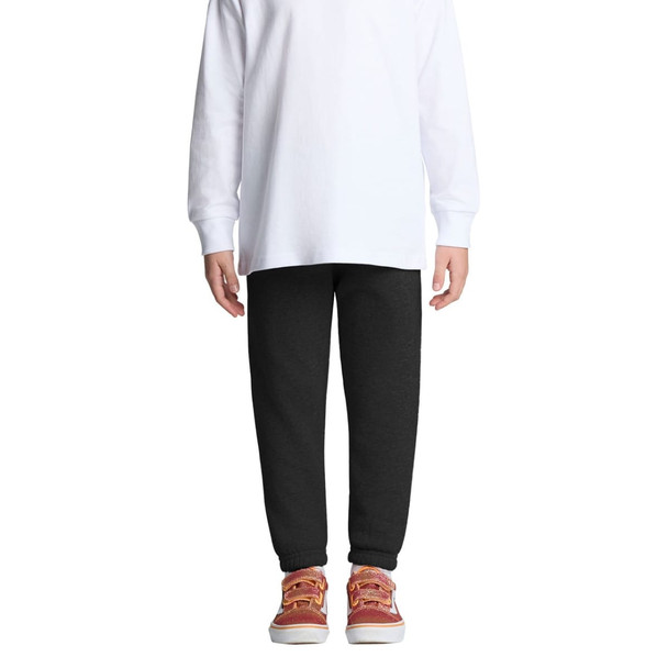 Black track pants for kids, featuring an elastic waistband and cuffs, paired with a white long-sleeve top and casual shoes. Black track pants for kids, featuring an elastic waistband and cuffs, paired with a white long-sleeve top and casual shoes.
