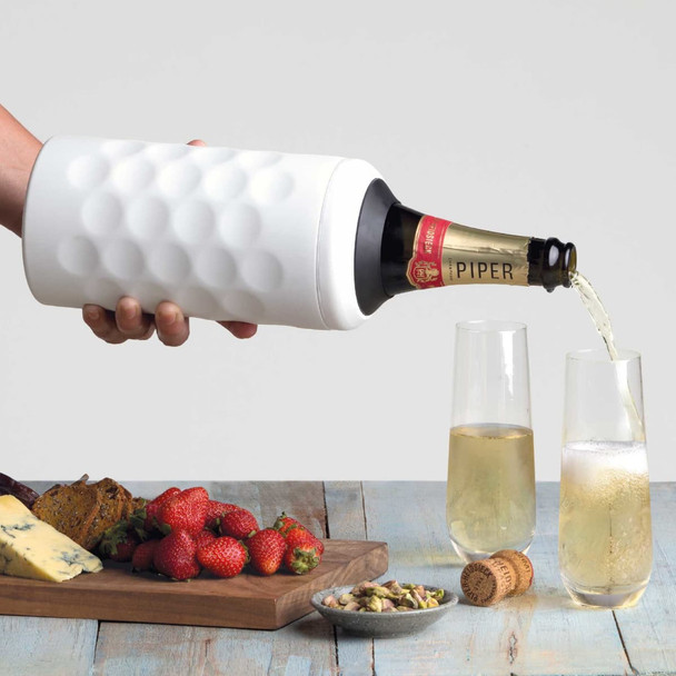 A drink bottle in white with a textured surface, holding a sparkling wine being poured into two flutes, beside strawberries and cheese.