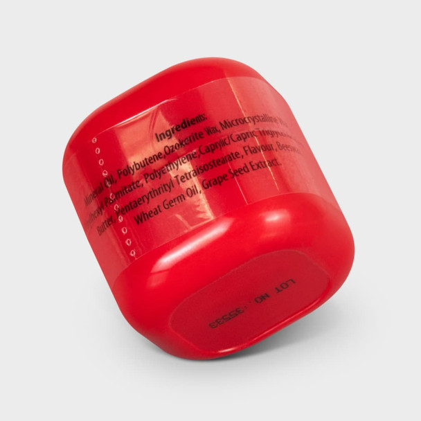 A red lip balm container with a rounded shape, featuring a logo and ingredients listed on the side.