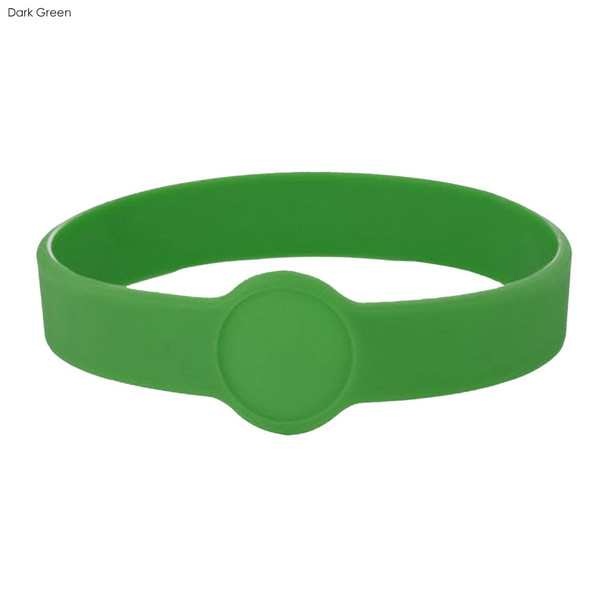 A dark green silicone wristband featuring a circular design element and a smooth finish.