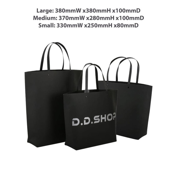 A set of three black boutique paper bags in varying sizes with handles and a logo.