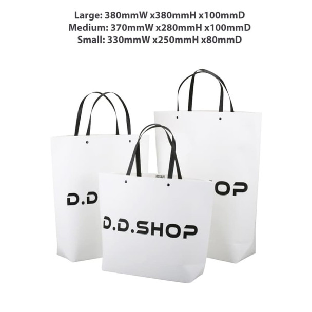 A set of three white boutique paper bags, featuring black logos, in various sizes: small, medium, and large.