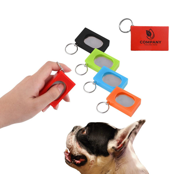 A set of pet training clickers in red, black, green, orange, and a hand holding one. The clickers have a keychain attachment.