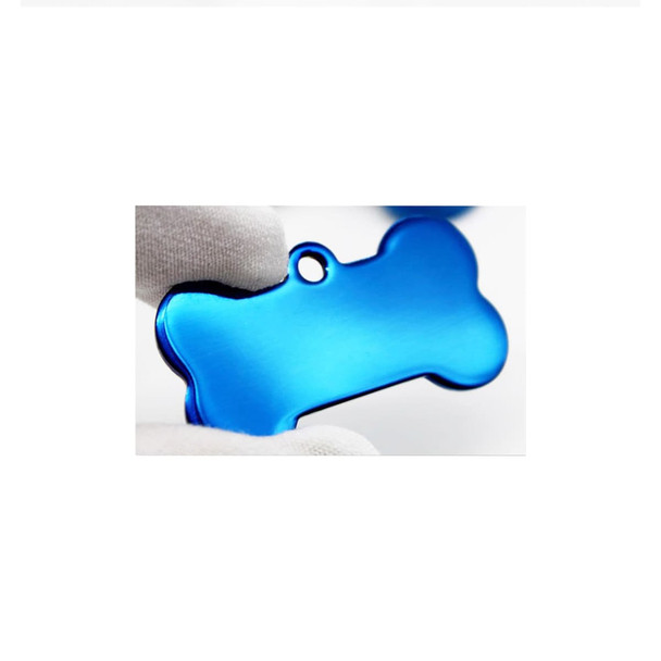 A blue bone-shaped pet ID tag being held by two fingers, featuring a hole for attachment. A blue bone-shaped pet ID tag being held by two fingers, featuring a hole for attachment.