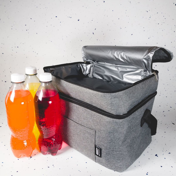 A grey cooler bag with a silver interior sits alongside three plastic drink bottles filled with colourful liquids.