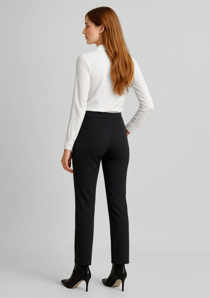 A woman in a white top and black mid-rise pull-on pants, standing with her back to the camera.