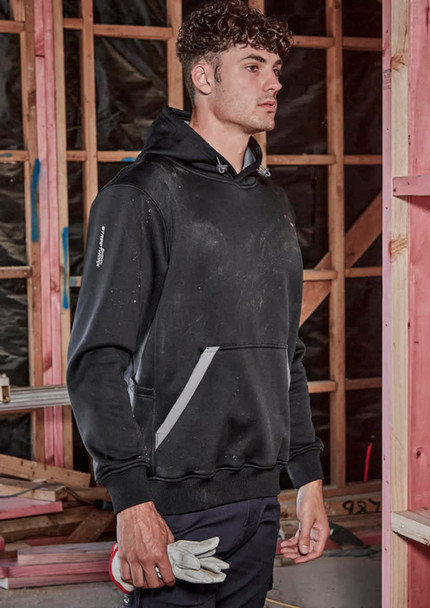 A unisex water-resistant hoodie in black, featuring a logo and pockets, worn by a model in a construction setting.
