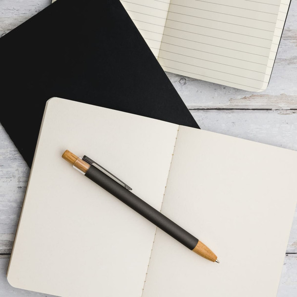 A Serenity Aluminium Pen rests on an open blank notebook, accompanied by a lined notebook and a black notebook. A Serenity Aluminium Pen rests on an open blank notebook, accompanied by a lined notebook and a black notebook.