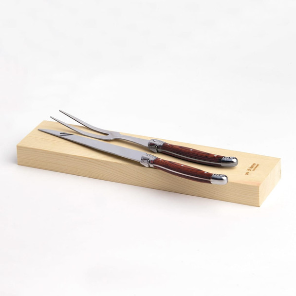 A stainless steel carving set with wooden handles, resting on a wooden presentation box.