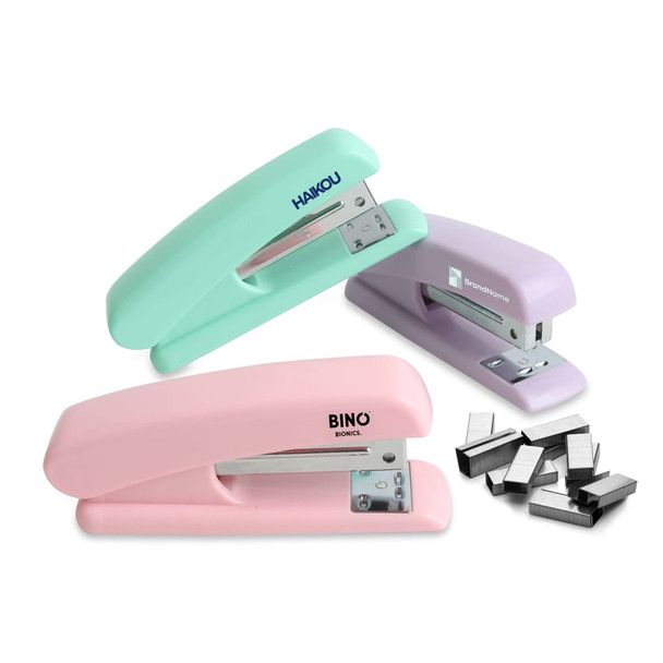 A stapler set featuring mint green, pink, and purple staplers, with a group of silver staples beside them.