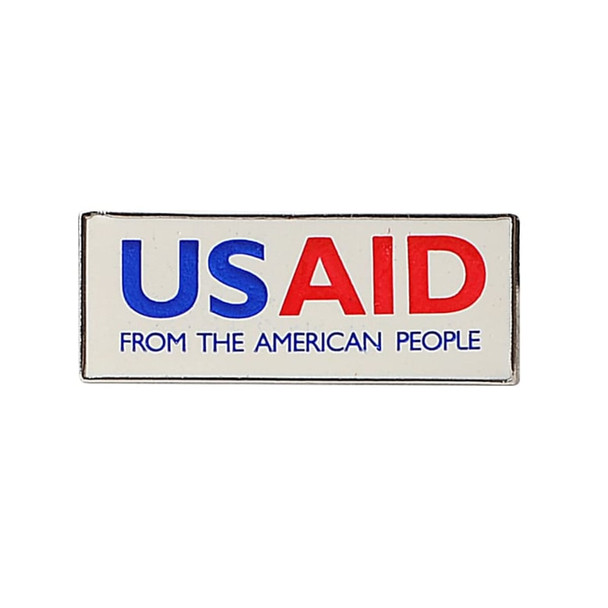 A rectangular lapel pin in blue, red, and white colours featuring a logo and text.