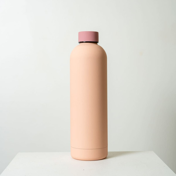 A drink bottle in a soft pink hue with a matte finish and a contrasting pink lid. It features a logo. A drink bottle in a soft pink hue with a matte finish and a contrasting pink lid. It features a logo.