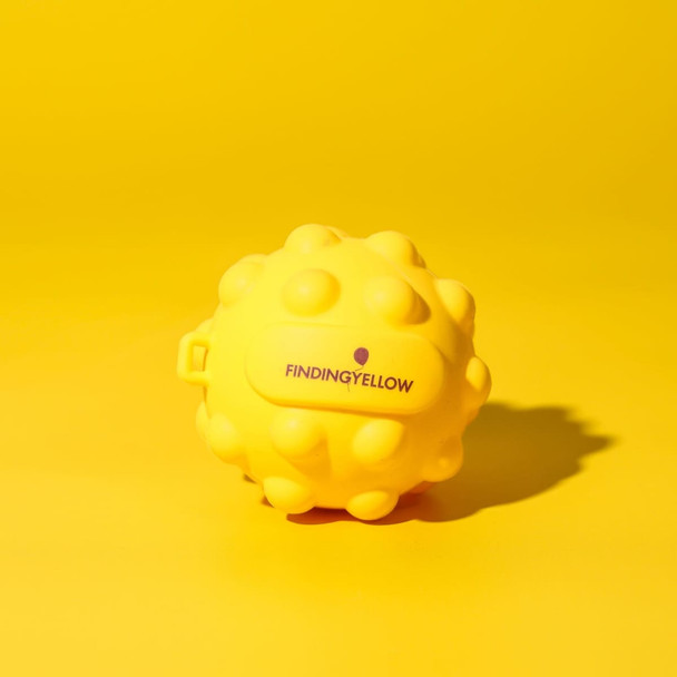 A yellow stress ball with a textured, spiky surface, featuring a small logo on it.