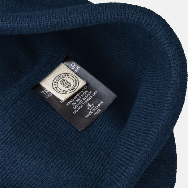 A navy blue beanie with a textured exterior and a label inside. The beanie features a visible logo. A navy blue beanie with a textured exterior and a label inside. The beanie features a visible logo.